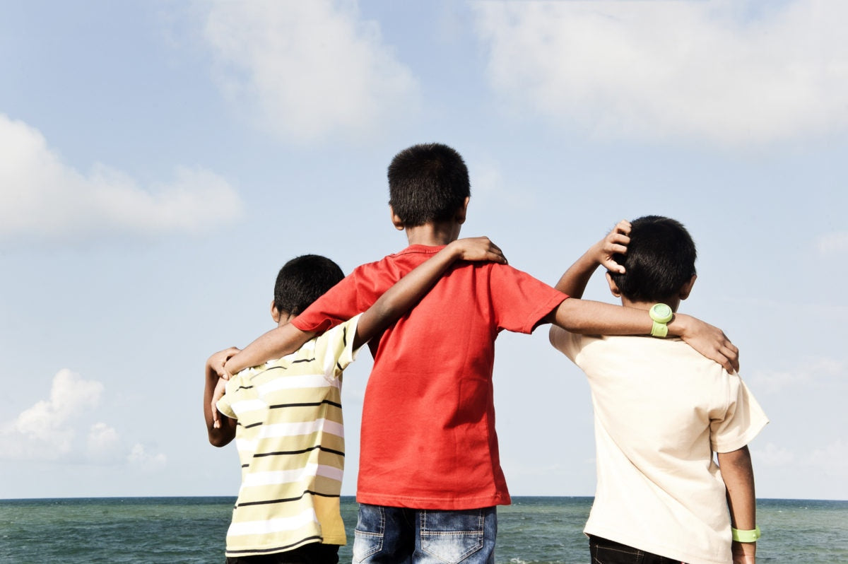 three boys holding each other around the back