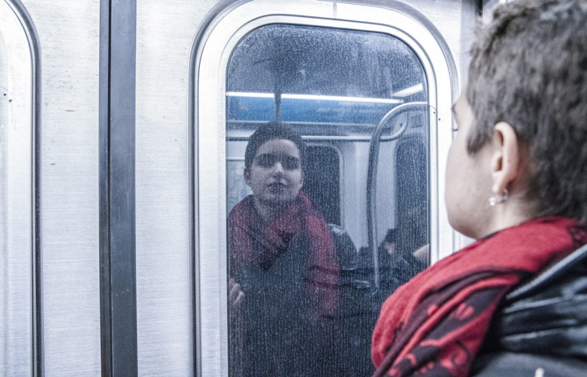 A lady is watching mirror inside metro train