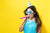 woman with party hat with noisemaker on a yellow background