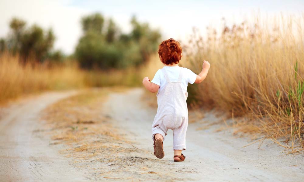 baby boy running away along the path