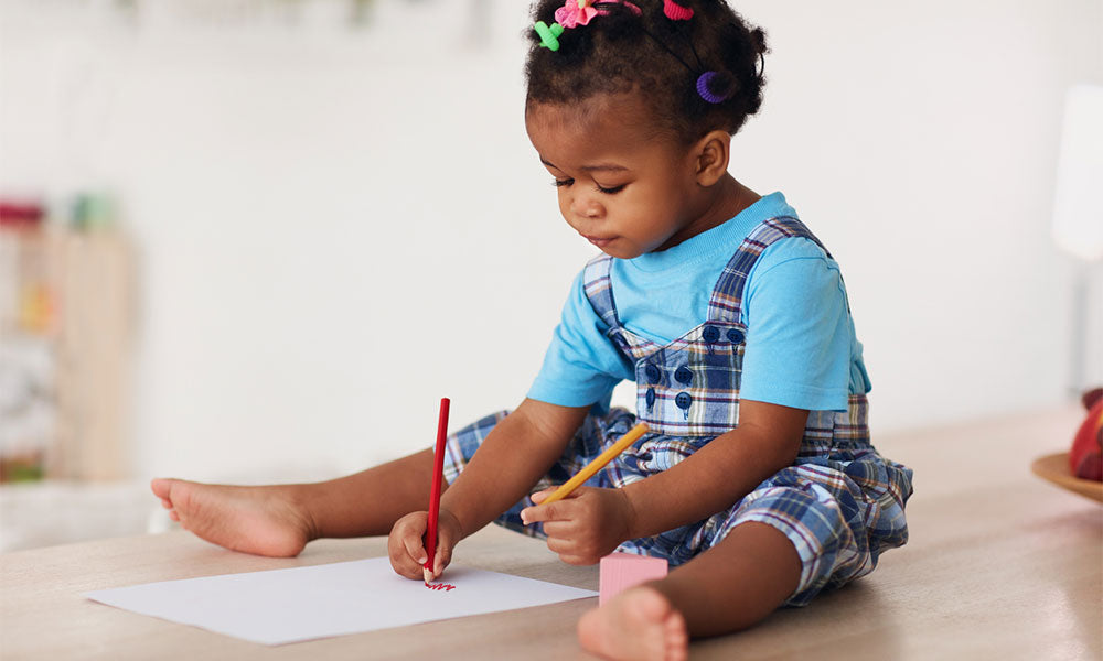 baby girl drawing with pencils