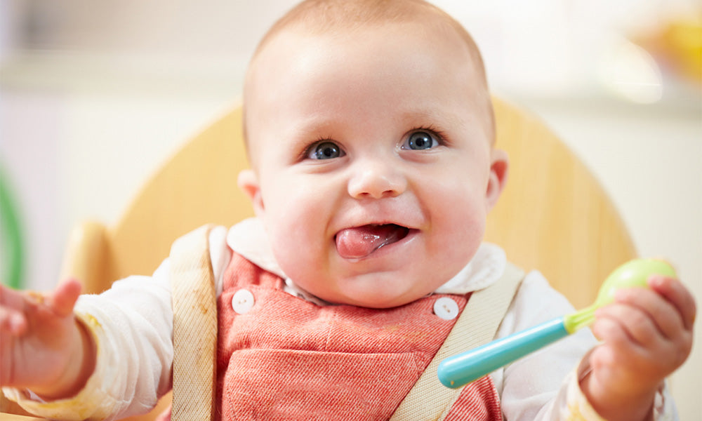 happy young baby boy in high chair