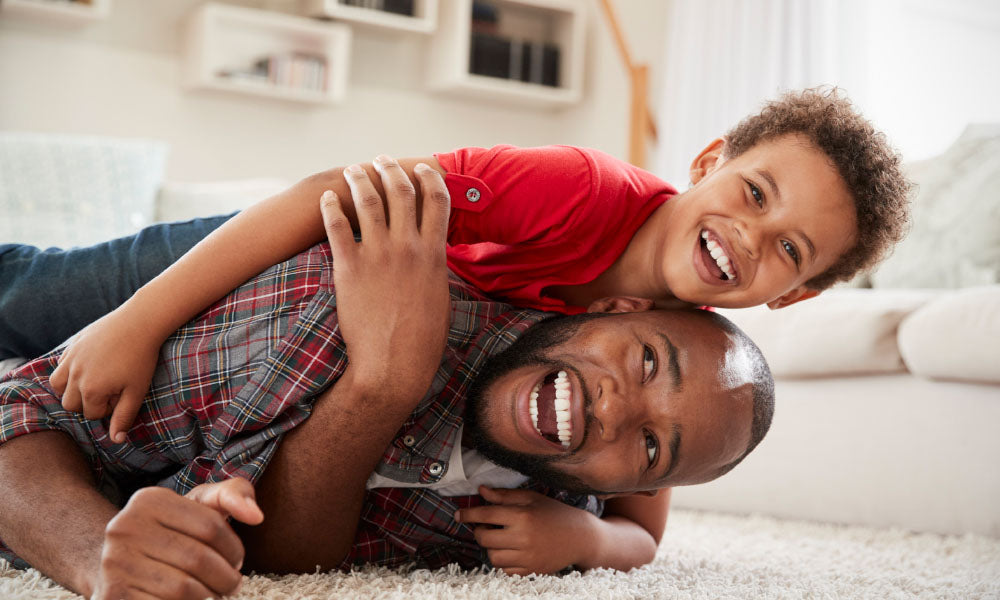 son climbs on fathers back as they play game