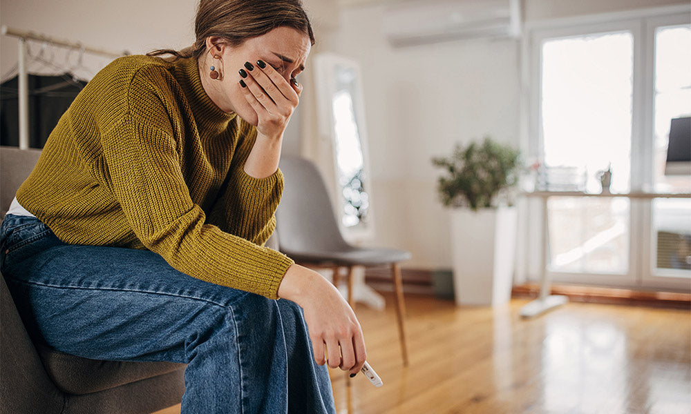  woman crying because pregnancy test is negative