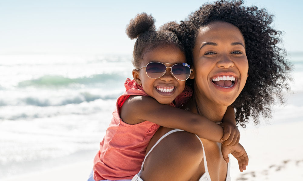 mother and daughter laughing at the beach